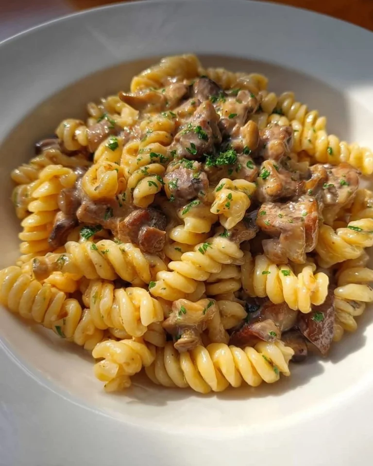 Fusilli con Salsiccia, Funghi e Noci serviti in un piatto elegante
