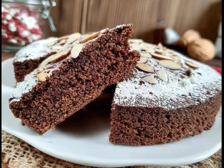 Fetta di torta di mandorle al cacao senza farina su un piatto decorativo.